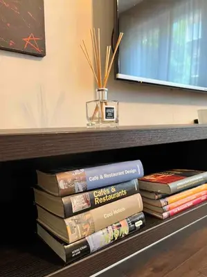 a stack of books sitting on a shelf at Perfectly Sumptuous Centre Apartment, 2-minute walk from Vitosha Boulevard in Sofia