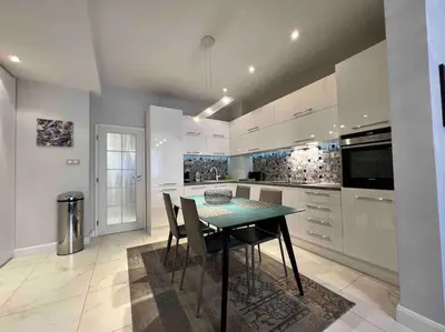 a kitchen with a table and chairs in a room at Perfectly Sumptuous Centre Apartment, 2-minute walk from Vitosha Boulevard in Sofia