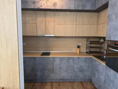 a kitchen with wooden cabinets and a counter top at Апартамент с двор Дива in Samokov