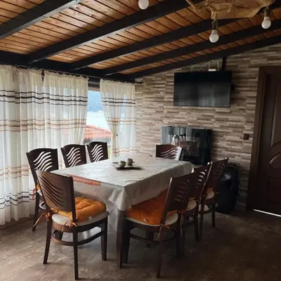 a dining room with a white table and chairs at Вила Сънсет 1 in Dospat