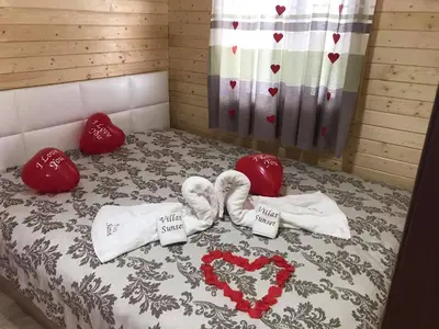 a bed with valentines towels and hearts on it at Вила Сънсет 1 in Dospat
