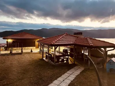 a house with a roof with a view of the water at Вила Сънсет 1 in Dospat