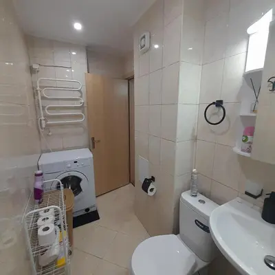 a bathroom with a toilet and a sink and a washing machine at lux apartament 88 in Bansko