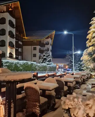 a row of tables covered in snow in front of a building at lux apartament 88 in Bansko