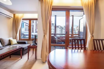 a living room with a couch and a table at Host2U Slope-Side Home by the Gondola in Bansko