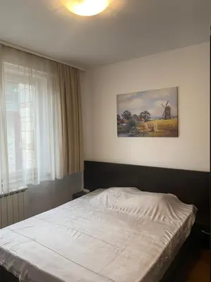 a bedroom with a bed with a painting on the wall at Bansko Royal Towers Apartment - top location in Bansko