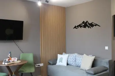 a living room with a couch and a table at Mountain studio ASP E63 Borovets Gardens in Borovets