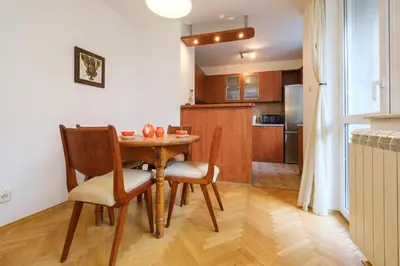 a kitchen and dining room with a wooden table and chairs at The Hill House Free Parking in Plovdiv