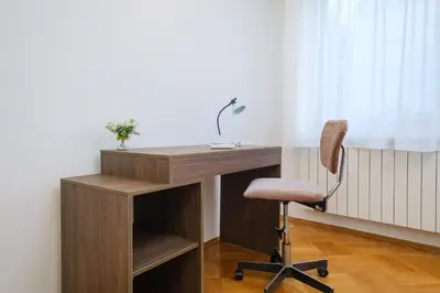 a wooden desk with a chair next to a window at The Hill House Free Parking in Plovdiv