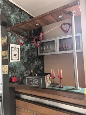 a bar with two wine glasses on a counter at Megan apartment Sofia Mall center in Sofia