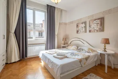 a white bedroom with a bed and a window at Aristocratic Elegant 2 BDRM spacious home TOP CENTER in Sofia