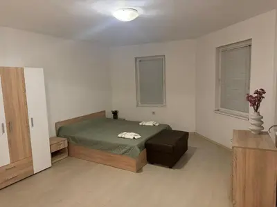 a bedroom with a bed and a chair in it at Апартамент за гости ''ЗДРАВЕ'' in Kyustendil
