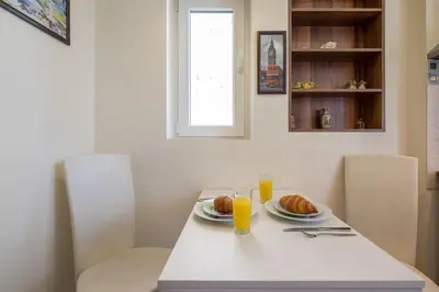 a table with two plates of food and two glasses of orange juice at Very Central & Aristocratic 2 Bedroom Apartment with Air conditioning in Sofia
