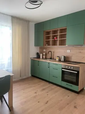 a kitchen with green cabinets and a sink and a table at Apartment Park View in Sandanski