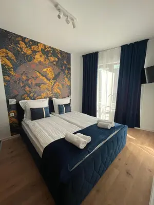 a bedroom with a large bed with a painting on the wall at Apartment Park View in Sandanski