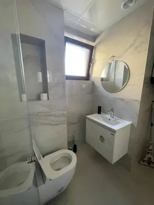 a bathroom with a white toilet and a sink at Apartment Park View in Sandanski