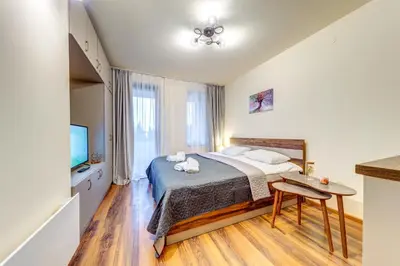 a bedroom with a bed and a table and a tv at Cozy Studio in Grand Resort Pamporovo by Flat Manаger in Pamporovo