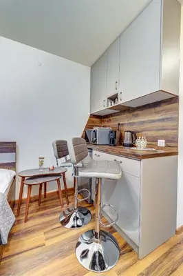 a kitchen with a counter and two bar stools at Cozy Studio in Grand Resort Pamporovo by Flat Manаger in Pamporovo
