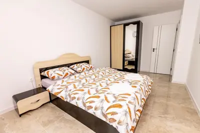 a bedroom with a large bed and a mirror at Apartment Golden Park in Sandanski