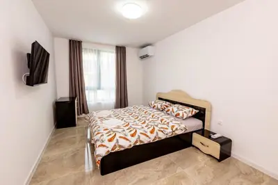 a bedroom with a bed and a flat screen tv at Apartment Golden Park in Sandanski