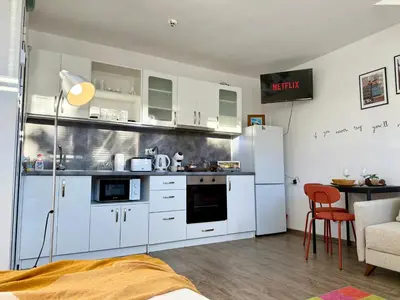 a kitchen with white cabinets and a white refrigerator at Comfy Studio by Cosher in Sofia