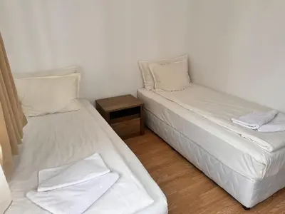 two beds in a room with white sheets and pillows at Sunny two bedroom apartment 12 in Tulip , Flora Residence - prime location! in Borovets