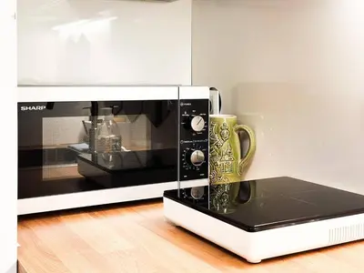 a microwave oven with a mug in front of it at Central Duplex Wi-Fi, Kitchen, Netflix, Heating in Sofia