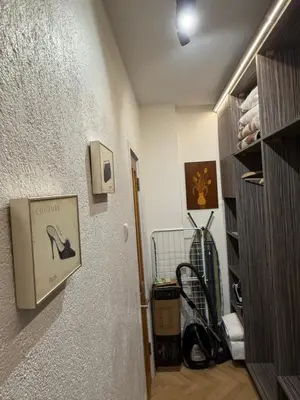 a hallway with a door to a room with a shelf at Апартамент ГТ in Plovdiv