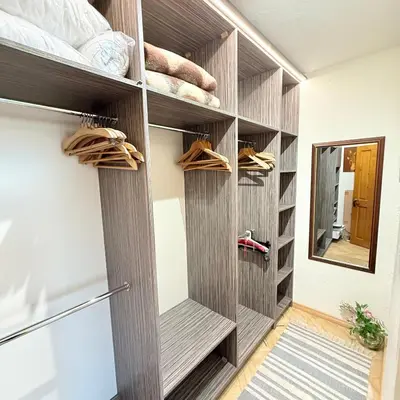 a walk in closet with wood paneling and a mirror at Апартамент ГТ in Plovdiv