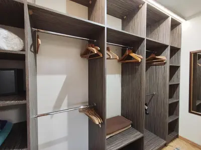 a walk in closet with wooden shelves and shoes at Апартамент ГТ in Plovdiv