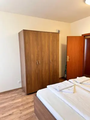 a bedroom with a bed and wooden cabinets at Apartment for 6 in Flora main building - prime location! in Borovets