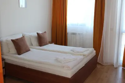 a bedroom with a bed with white sheets and a window at Apartment for 6 in Flora main building - prime location! in Borovets