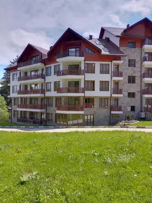 a large building with a grass field in front of it at Студио 36 - Семирамида, Боровец in Borovets