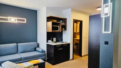 a living room with a blue couch and a table at Passion & Sense Studios Pamporovo in Pamporovo