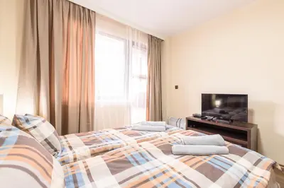 a bedroom with two beds and a television at Liftside Alpine Suite in Bansko