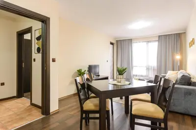 a living room with a dining room table and a couch at Liftside Alpine Suite in Bansko