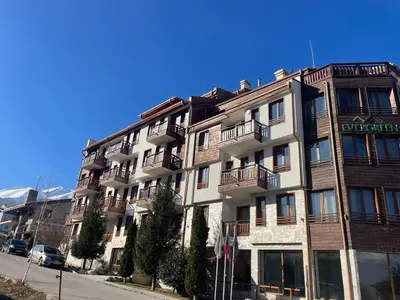 an apartment building on the side of a street at Mountain view 1-bedroom apartment few steps from ski piste and Gondola lift in Bansko