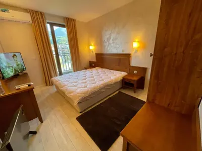 a bedroom with a bed and a large window at English Apartments 2 in Bansko