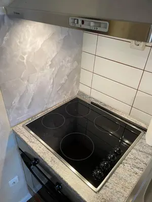 a black stove top oven in a kitchen at English Apartments 2 in Bansko