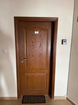 a wooden door in a hallway with a mat at Mimsi Apartment in Pamporovo