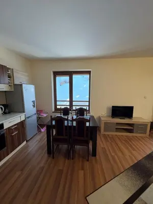 a living room with a table and a kitchen at Mimsi Apartment in Pamporovo