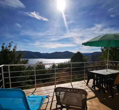 a patio with chairs and a table and an umbrella at Lakeview Estate Chalet in Staro Myasto