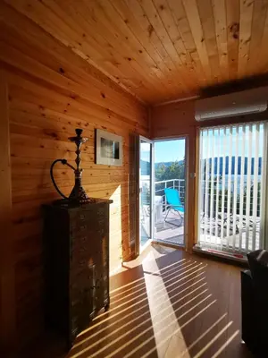 a room with wooden walls and a large sliding glass door at Lakeview Estate Chalet in Staro Myasto