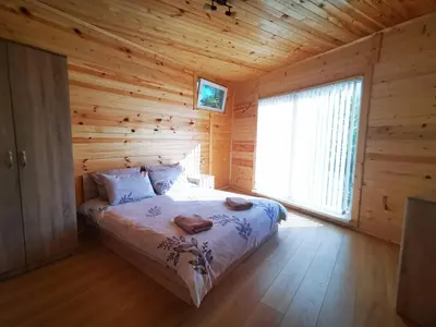 a bedroom with a bed in a log cabin at Lakeview Estate Chalet in Staro Myasto