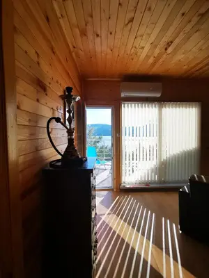 a room with wooden walls and a large window at Lakeview Estate Chalet in Staro Myasto