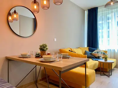 a living room with a table and a yellow couch at Apartment with Free Underground Parking by COSHER in Sofia