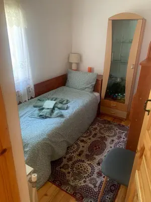 a small bedroom with a bed and a chair at Villa Popovi in Simitli
