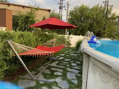 a hammock and an umbrella next to a swimming pool at Villa Popovi in Simitli