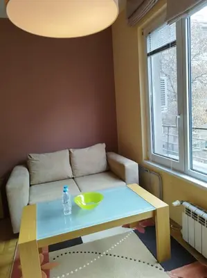 a living room with a table and a couch at The Cathedral in Sofia