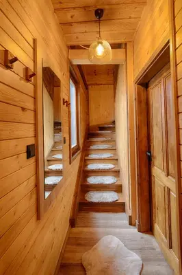 a hallway of a wooden cabin with stairs and a door at Rich House Velingrad in Velingrad